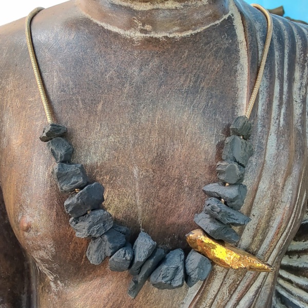 hanger donker grijze keramiek waarvan het grootste stuk bezet is met 24karaat goud, een bijhorende zilveren met 24 karaat verguld ketting van onze parijse ontwerpster